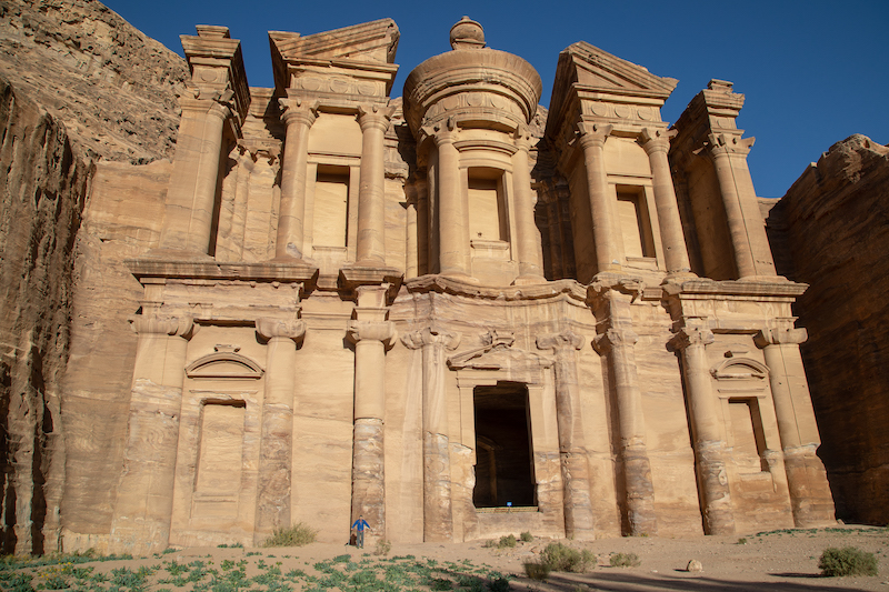 a photo of erik standing at base of entrance to petra