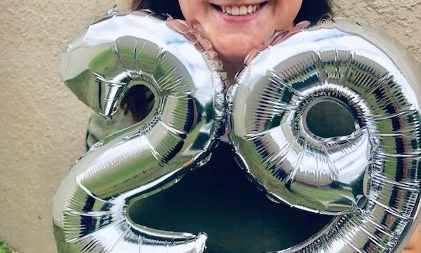 a photo of a smiling meagan with balloons with twenty-nine on them