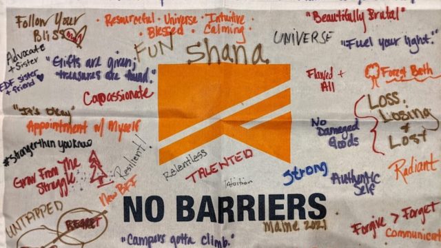 Blog post feature image: A No Barriers Flag with words of empowerment handwritten on it in sharpie, part of an exercise focused on resiliency, hope, and healing that took place at the 2021 No Barriers Caregivers Retreats at the Adaptive Outdoor Education Center in Carrabassett Valley, Maine.