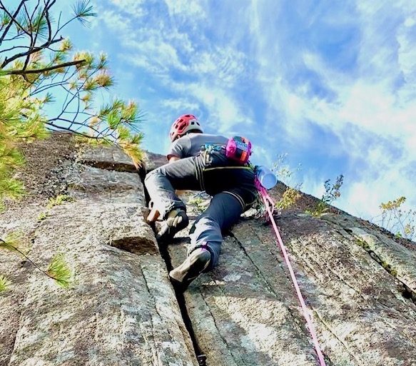 Erik navigating a crack with sunny skies above.