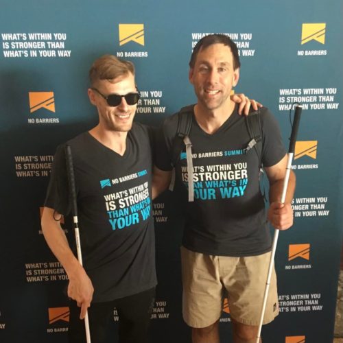 Erik and Casey at the 2017 No Barriers Summit holding canes and wearing No Barriers shirts.