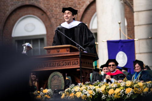 Erik leaning forward at the lectern as he gives his commencement address