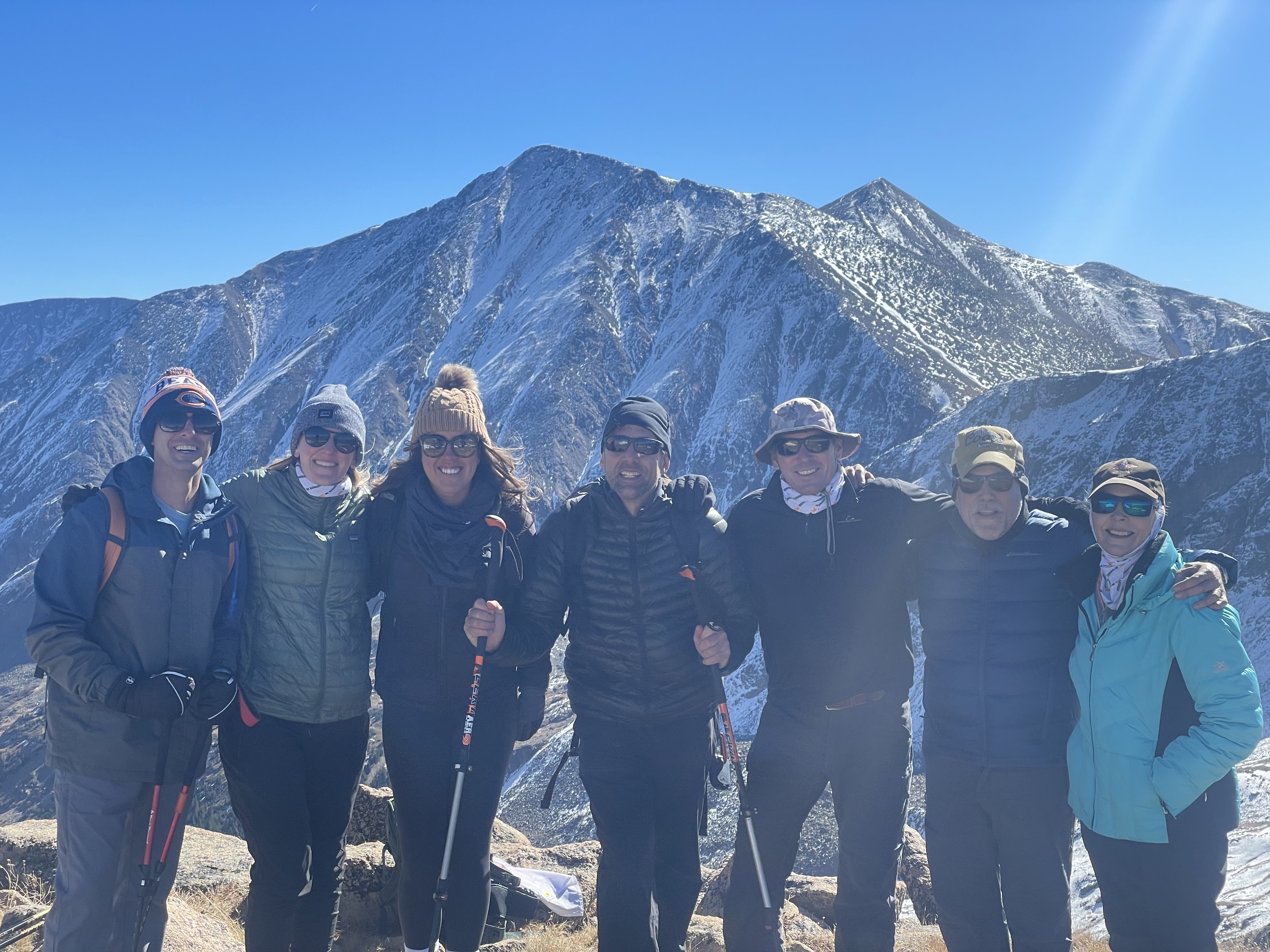 Erik and six (6) iCIMS team members taking a photo with the mountains rising above in the background.
